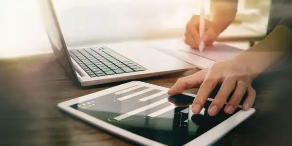 man using a laptop and a tablet at the same time